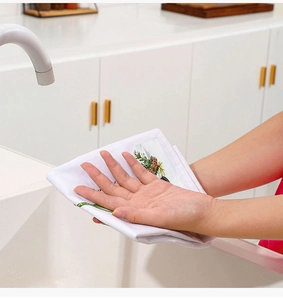 Nahaufnahme eines weißen Küchenhandtuchs mit gelbem Blumendruck am Spülbecken