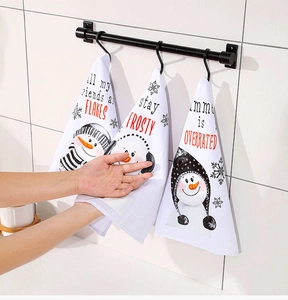 Asciugamani natalizi con pupazzo di neve e scritte festive appesi a un’asta nera