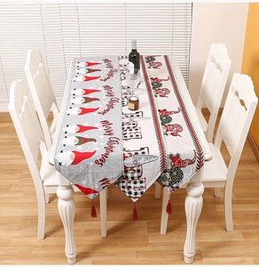 Close-up of knitted Christmas table runners with festive gnome patterns and red tassels
