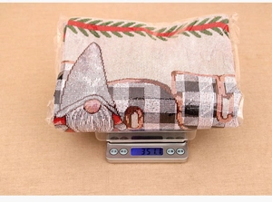 Detailed weight measurement showing 351g for the festive gnome pattern table runner