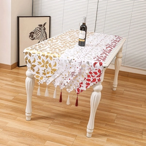 Christmas table runner with gold and red holly patterns and tassels for home decor