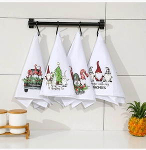 Detailed view of four Christmas themed kitchen towels featuring gnomes and holiday motifs