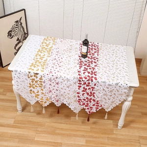 Elegant Christmas table runner with gold prints and colorful tassels for festive decor