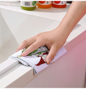 Action shot of festive Christmas gnome microfiber towel wiping a white marble surface