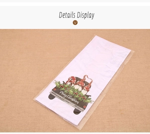 Detailed view of Christmas gnome hand towel with festive black truck print in packaging
