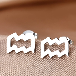 Macro shot of silver wave earrings on champagne silk background with butterfly backs