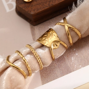 Set of five gold stainless steel rings with twisted, hammered, and wave geometric designs