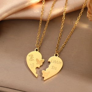 Golden big sis little sis heart pendant necklaces set on elegant silk background