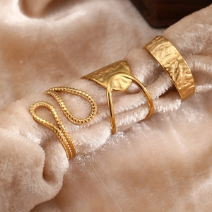 Close-up of three gold geometric rings with hammer texture and twisted rope design
