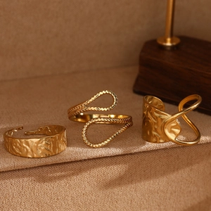 Detailed view of three golden geometric rings featuring textured and twisted designs