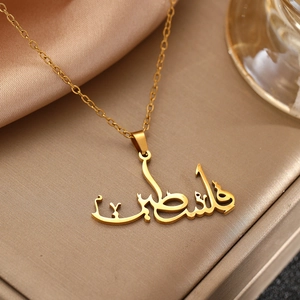 Gold stainless steel necklace with Arabic Palestine calligraphy pendant on beige velvet