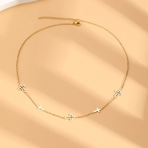 Detailed view of gold stainless steel necklace with hollow and solid cross pendants