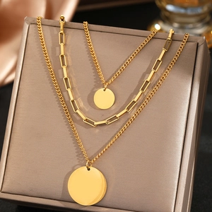 Three-layer gold stainless steel necklace with coin pendants on premium silk background