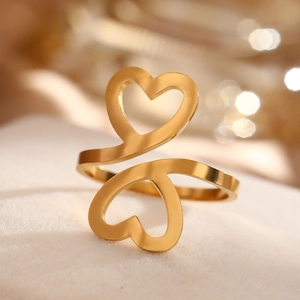 Vue macro d'une bague double cœur plaquée or poli sur un fond en velours crème