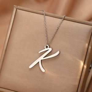 Vue macro du pendentif lettre R en argent brossé sur écrin à bijoux avec soie