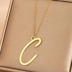 Vue rapprochée d'un collier doré avec pendentif lettre C et finition miroir lisse