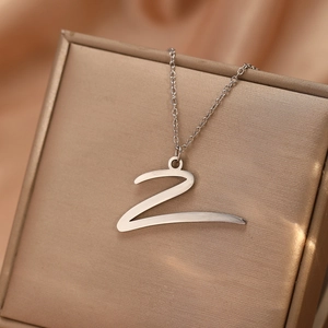 Vue détaillée du collier pendentif lettre Z argentée sur une boîte à bijoux champagne