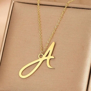 Détail du collier lettre A doré en acier inoxydable poli sur son support élégant