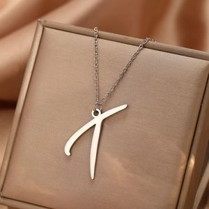 Détail du collier avec pendentif lettre T en argent présenté dans un écrin de luxe
