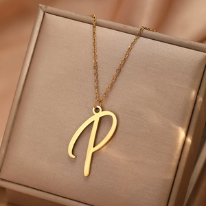 Détail du pendentif lettre P doré sur un tissu en soie dans une boîte à bijoux