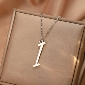 Gros plan d'un collier en acier inoxydable argenté avec pendentif chiffre 1 sur boîte