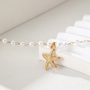 Vue macro détaillée d'un pendentif étoile de mer doré et chaîne en perles