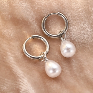 Elegant teardrop pearl drop earrings with polished silver metal hoops on velvet