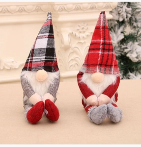 Nahaufnahme von Weihnachtsgnom-Plüschpuppen mit Karomuster an einem weißen Kamin