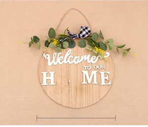 Detailed view of round wooden welcome sign with eucalyptus, bow and relief lettering