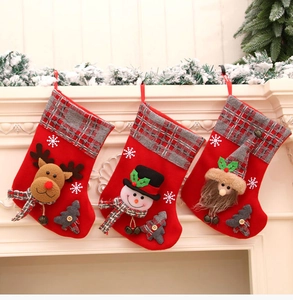 Detailed view of 3D reindeer, snowman, and gnome plush ornaments on Christmas stockings