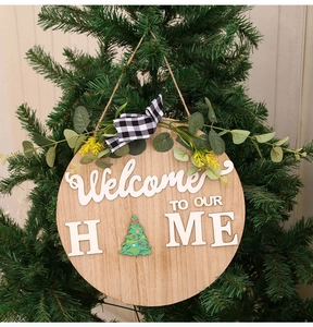 Detail of wooden welcome home sign with buffalo plaid bow and festive Christmas tree icon