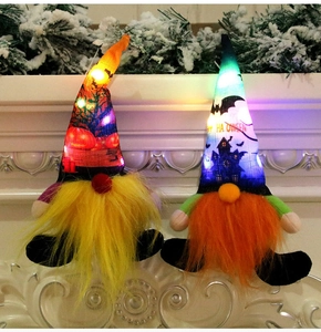 Close-up of glowing Halloween gnomes with LED lights, pumpkin and bat patterns