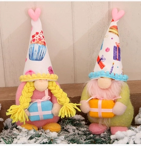 Detail of plush Valentine gnomes with heart hats holding gift boxes on snowy wood background