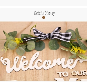 Detail display of wooden welcome sign with eucalyptus leaves and plaid bow decoration