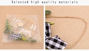 Detail of wooden welcome home sign showing rustic jute rope and plaid bow decoration