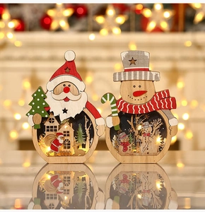 Detail of laser-cut wooden Christmas Santa and Snowman ornaments with LED glowing lights