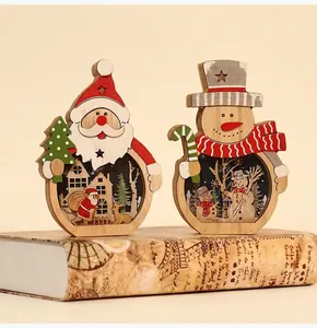 Detail of handcrafted wooden Santa and Snowman LED ornaments on vintage books in warm light