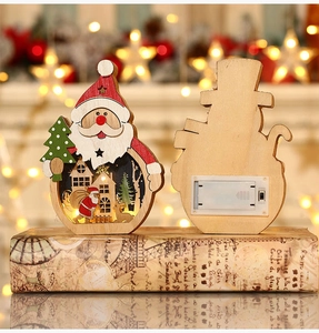 Close-up of wooden LED Santa Claus ornament with intricate glowing winter scene