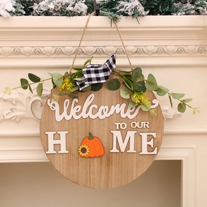 Wooden Welcome To Our Home door sign with pumpkin icon, greenery, and plaid bow