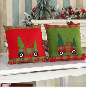 Detail of red and green velvet Christmas pillow covers with truck embroidery and plaid edges