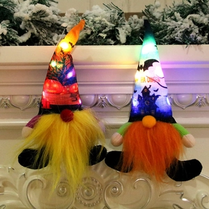 Set of two glowing Halloween gnomes with LED lights on a white mantelpiece