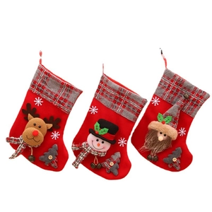 Three medium Christmas stockings with 3D Santa, Snowman and Reindeer on red plaid flannel