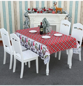 Detail of Christmas tablecloth featuring red plaid pattern and festive gnome illustrations