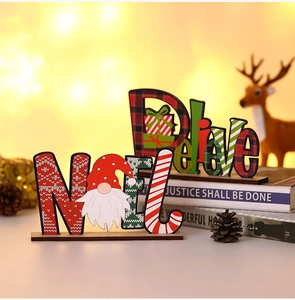 Macro view of Noel and Believe wooden Christmas gnome ornaments on decorative books