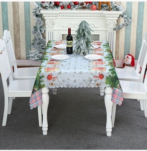Close-up of festive Christmas tablecloth with snowflake and bell patterns on a white table