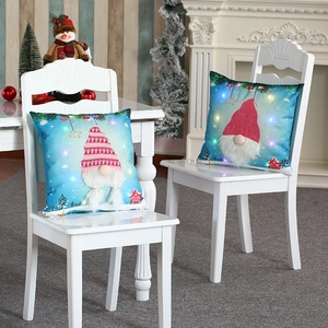 LED light-up Christmas gnome pillow covers with plush texture on a white chair