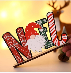 Close-up of wooden NOEL Christmas gnome tabletop sign with warm bokeh background