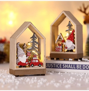 Detailed view of LED lighted Christmas wooden house ornaments with warm laser cut scenes