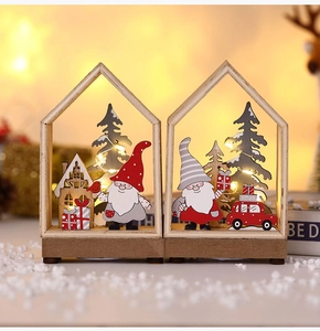Detail of wooden Christmas LED house ornaments with Santa and pine tree on faux snow
