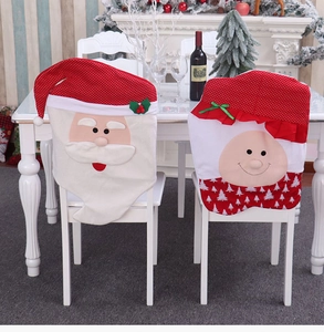 Detail showing Santa Claus and Elf chair covers on dining chairs in a cozy festive setting